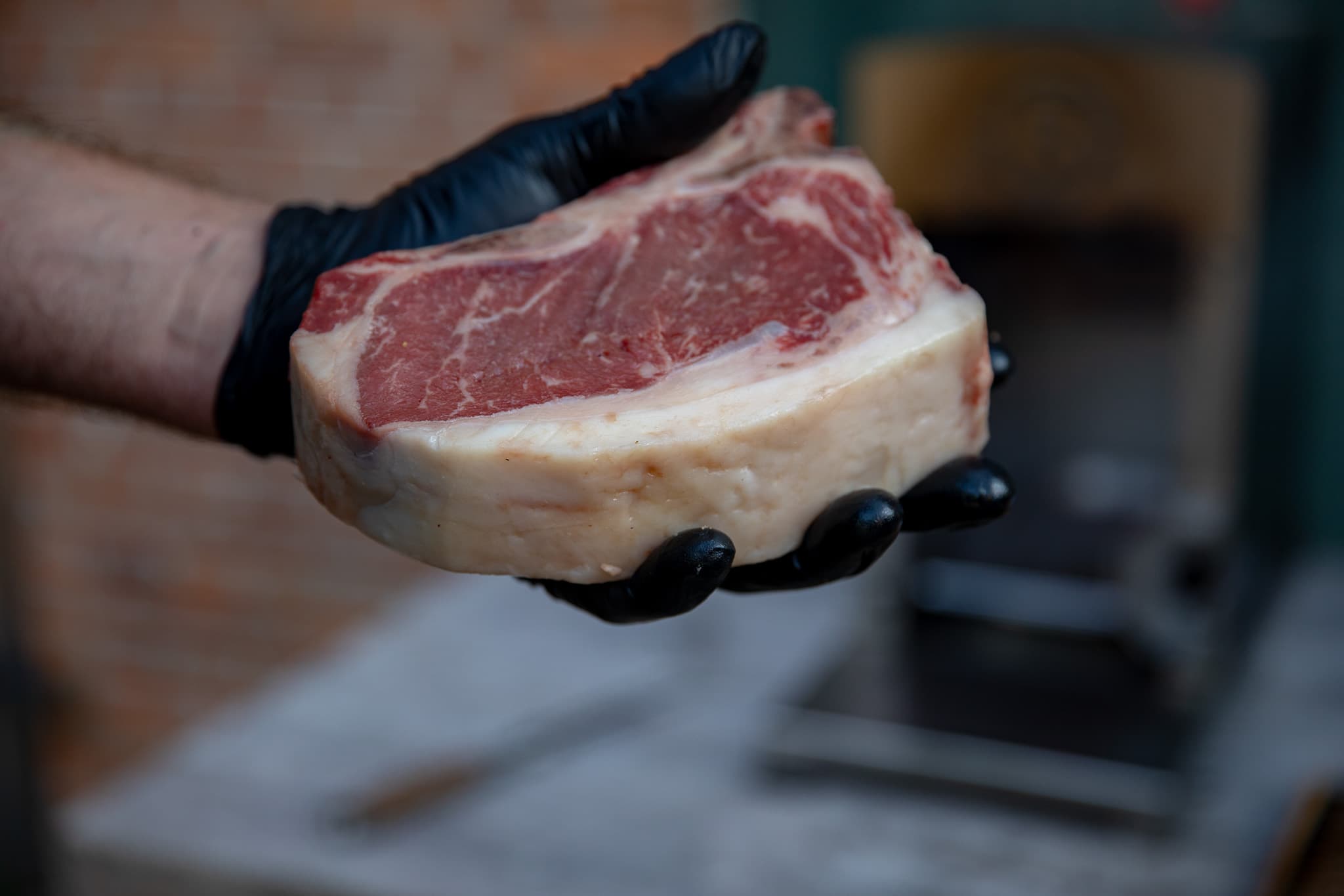 Cote de Boeuf vom Angus am Knochen, in der Manufaktur in der Hand gehalten