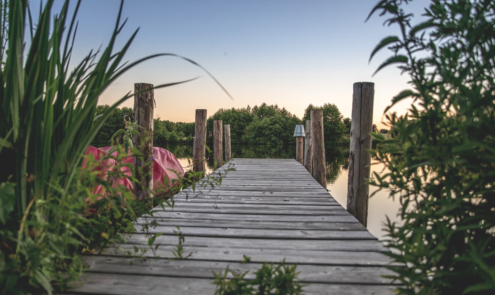 Holzsteg im Mühlenteich bei Sonnenuntergang