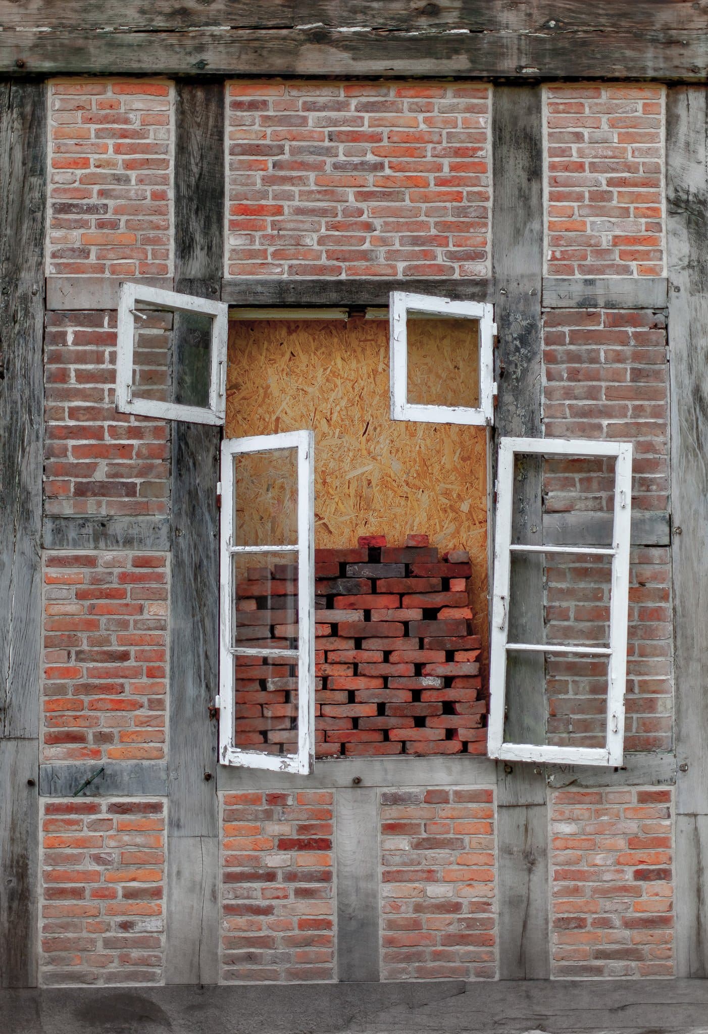 Fachwerk-Fenster im Detail, alte weiße Rahmen vor neu gemauertem Backstein